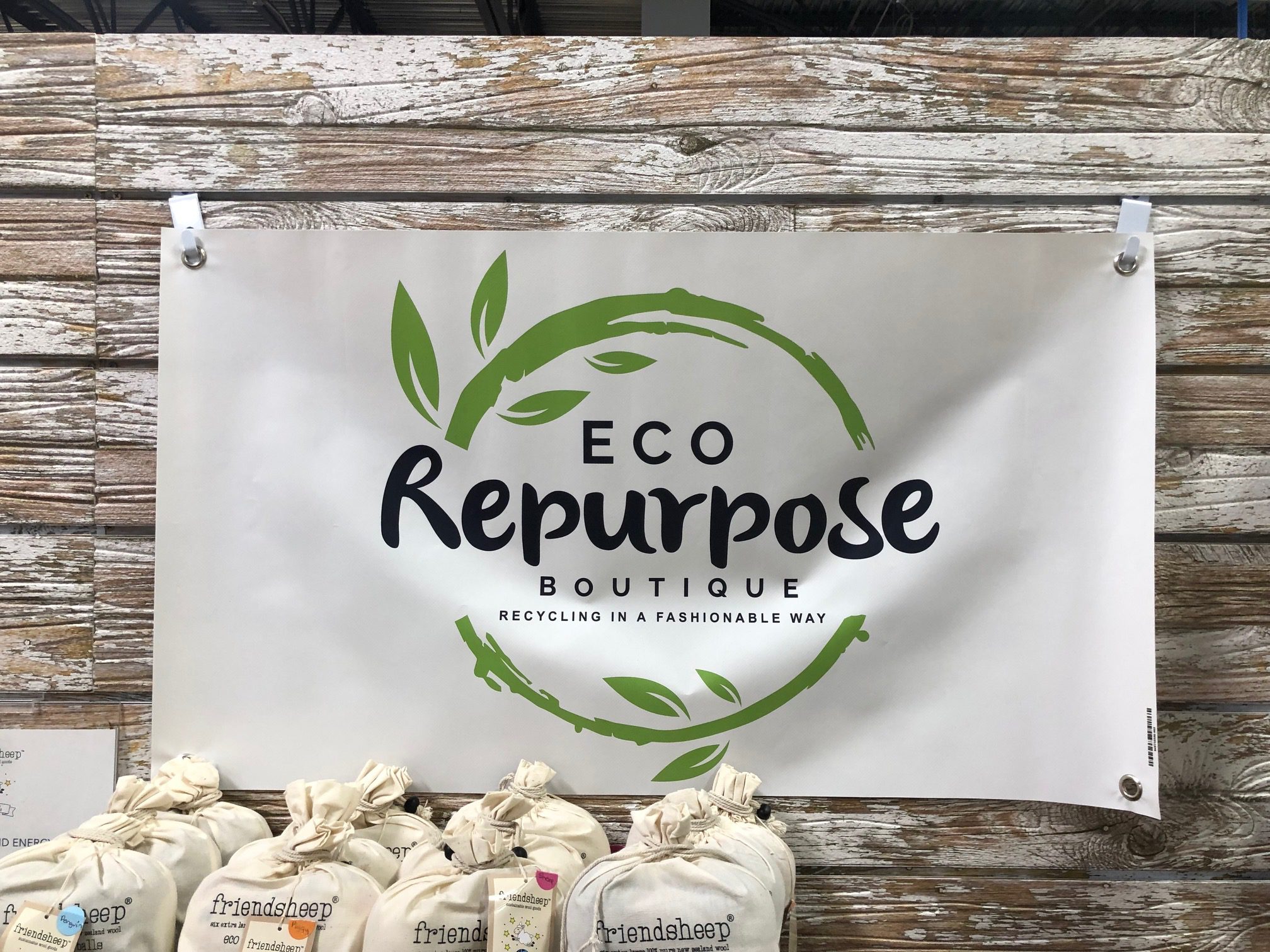 Eco Repurpose Boutique logo on a banner hanging on the wall.